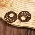 Exaggerated geometric hollow wooden hoop earrings with sunburst pattern on wood tray - Dark Brown