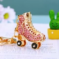 Glitzernder rosa Rollschuh-Schlüsselanhänger aus Goldmetall für Damenhandtaschen - Rosa