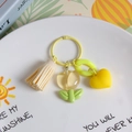 Yellow resin tulip keychain with beige tassel and heart charm on decorative plate - Transparent Light Yellow Tulip