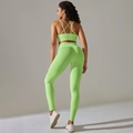 Detail of lime green ribbed yoga set featuring cross-back bra and high-waist leggings - Cyan