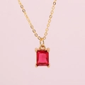 Gold chain necklace featuring a rectangular red gemstone pendant on a soft pink background - Red