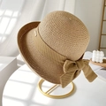 Handwoven straw sun hat with decorative ribbon bow and metallic logo on a round stand - M (56-58cm) / Khaki