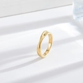 Minimalist Mobius twist ring in 18k gold plated stainless steel on a white textured surface - Möbius Ring Gold