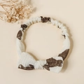 Close-up of baby cotton bow headband featuring brown bear patterns on creamy white fabric - Cartoon Bear