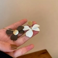 Handheld view of elegant black and white tulip flower earrings with golden accents - Matte Three-petal Flower (Silver Earring Post. Brown)