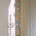 Blue crystal moon suncatcher with evil eye gold frame creating rainbow light patterns - Light Blue