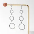 Elegant silver tassel earrings with three tiered crystal rings on a golden display stand - Three Circles Silver