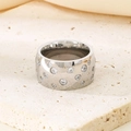 Macro shot of silver titanium steel ring with inlaid diamonds on a beige stone surface - 11mm / Star Zircon Style (KR89952-K)