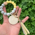 Detailed view of yellow and marble silicone bead keychain with tassel and wood pendant - Yellow Marble Color (款2)