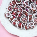 Macro detail of hand-painted gingerbread style beads for DIY jewelry and phone charms - Coke Bead Red White Cream