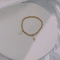Close-up of gold beaded bracelet with a white pearl and lightning bolt charm detail - Gold-Lightning