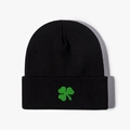 Close-up of green clover embroidery on black knitted beanie with detailed wool texture - One Size / Embroidered Green Clover / Black