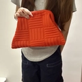 Pochette arancione in maglia con trama a intreccio e chiusura a scatto in metallo - Borsa a mano intrecciata / Arancio intrecciato 3D