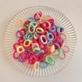 Elastic macaron hair ties in pastel colors presented on a clear striped glass plate - Candy Color 100Pcs OPP Bag