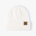 White ribbed knit beanie with brown leather logo patch for winter outdoor warmth - One Size / Soft White