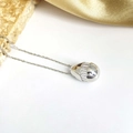 Macro de pendentif capsule argenté serti de zircons sur tissu en soie dorée de luxe - Collier Goutte d'Eau Zirconia Horizontal Argent