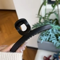Dettaglio della molletta nera opaca con denti antiscivolo e molla in metallo resistente - Nero opaco