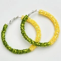 Macro detail of oversized green and yellow glitter hoop earrings for sports events - Yellow and Green