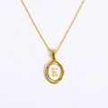 Detail eines goldenen ovalen Anhängers mit weißem Inlay und goldenem Buchstaben E - Buchstabe E / Gold