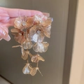 Dettaglio di orecchini a fiore dorati con nappe lunghe e strass scintillanti - Fiore dorato (2# Ago d'argento)