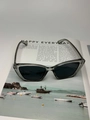 Detalle de gafas de sol gris humo semitransparentes sobre una revista de moda - Marco Gris Transparente Lentes Grises