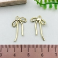 Golden bow-shaped alloy pendants for jewelry making with scale showing 2cm size - Hollow Bowknot - KC Gold (21398)