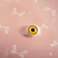 Macro detail of amber acrylic boat-shaped doll eye with realistic iris texture - Yellow Stripes