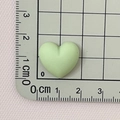 Detail view of a 2.5cm light green macaron resin heart charm on a scale measurement mat - Fruit Green