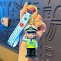 Cartoon police keychain with green vest and blue strap with white Police text - Salute Traffic Police