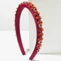 Detail of luxury burgundy padded headband featuring dense shimmering red rhinestones - Red