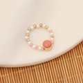 Dettaglio macro dell'anello di perline fatto a mano con pietra rosa e base dorata - Rosso Anguria