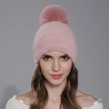 Pale pink winter knitted beanie for women featuring a large fluffy faux fur pom-pom topper - Pink
