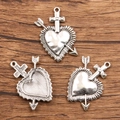 Antique silver heart charms with cross and arrow, front and back view on dark wood - 27B2-1 Arrow Sacred Heart