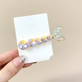 Macro detail of mermaid tail hair clip with iridescent crystals on gold alloy frame - Pink