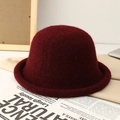 Close-up of a burgundy wool bucket hat with rolled edge detail on art newspaper - Burgundy