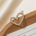 Golden heart pendant with sparkling white rhinestones on a soft silk background - Irregular Hollow Heart