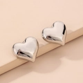 Primo piano di orecchini a cuore in argento con finitura a specchio lucida su supporto - Orecchini a Cuore / Argento