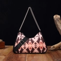 Aztec bohemian underarm bag with pink geometric pattern and dual straps on wooden desk - Tea Brown