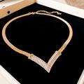 Detailed view of a gold snake chain necklace with a V-shaped rhinestone pendant on velvet - 43# Necklace - Gold - Real Gold Plating