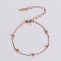 Dettaglio del bracciale in oro rosa con sfere lucide e catena a moschettone regolabile - Oro rosa