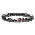 Close-up of black beaded stone bracelet featuring a polished rose gold crown charm detail - Smooth Rose Gold Small Crown