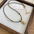 Dettaglio collana di perle occhio di tigre con pendente zucca oro opaco e zirconi - Stile con Perline Occhio di Tigre e Zucca Dorata (HN10966)