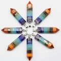 Radial arrangement of hexagonal seven chakra healing crystal pendants on white background - 7 Chakra Layered Style / Multicolor Hexagonal Prism