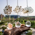 Set of 3 golden lotus suncatchers with crystal prisms hanging against a scenic background - 3-Piece Lotus Set