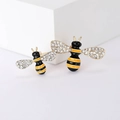 Sparkling enamel bee brooches with rhinestones and gold alloy base on white display - Yellow