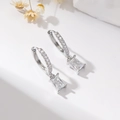 Detailed view of silver hoop earrings with rectangular zircon drop and pave stones - Rectangle