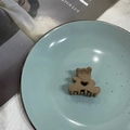Brown matte bear hair claw clip with heart cutout design on blue ceramic plate - Brown
