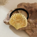 Golden shell and starfish metal hair tie on a beach rock for a summer resort style - Gold Shell Starfish