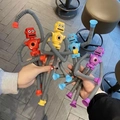 Close-up of four colorful suction cup robot toys with flexible telescopic tube limbs - No Light Version / 4-Color Robot Set