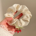 Detail of satin floral scrunchie with green ribbon bow and cute strawberry charms - Strawberry Pendant Style / Champagne